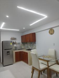 eine Küche mit einem Tisch und einem Kühlschrank aus Edelstahl in der Unterkunft Apartamento moderno frente al mar in Cartagena de Indias