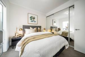 a bedroom with two beds and a large mirror at Urban Luxe - Designer, BBQ, WiFi in Keswick