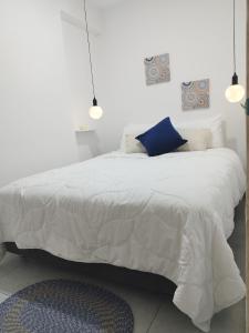 a bedroom with a white bed with a blue pillow at Apartamento moderno frente al mar in Cartagena de Indias