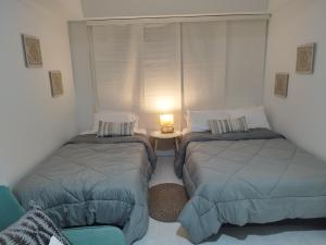 ein Schlafzimmer mit 2 Betten und einem Tisch mit einer Lampe in der Unterkunft Apartamento moderno frente al mar in Cartagena de Indias