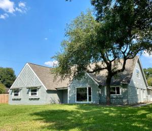 uma casa branca com uma árvore no quintal em 3300 sq Spacious Kitchen & Living Spaces ( 5 TVs ) em Houston