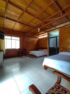 een slaapkamer met 2 bedden en een houten plafond bij Cabañas Ecowasi in Tingo María