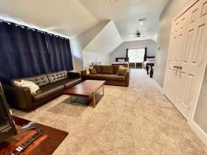 a living room with a couch and a table at 3300 sq Spacious Kitchen & Living Spaces ( 5 TVs ) in Houston