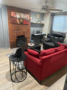 a living room with a red couch and a fireplace at Cuddys Place in Pittsburgh
