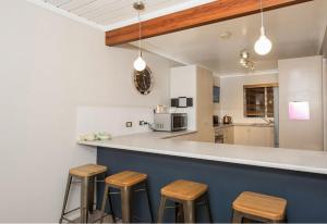 a kitchen with wooden stools at a counter at Erulisse in Jindabyne