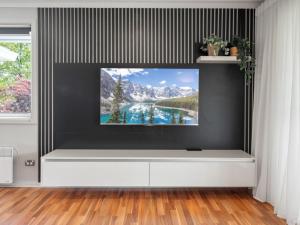 a living room with a tv on a wall at Gippsland 12 in Jindabyne