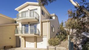 a house with a balcony on the side of it at Glacialis 6 in Jindabyne