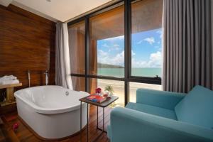 baño con bañera y ventana grande en The Code Hotel & Spa Da Nang en Da Nang