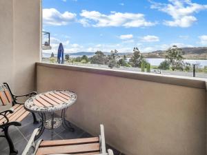 a balcony with a table and a view of the water at Jasper 1 in Jindabyne