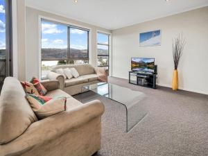 a living room with two couches and a tv at Jasper 1 in Jindabyne