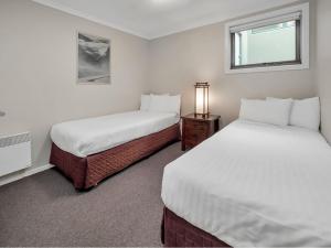 a bedroom with two beds and a window at Jasper 1 in Jindabyne