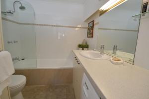 a bathroom with a sink and a toilet and a mirror at Karoonda 1 in Thredbo