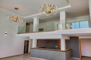 a lobby with two chandeliers and a staircase in a house at Luxurious Apt with Rooftop Pool in Dakar