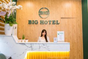 a woman standing behind a counter in a big hotel at BIG Hotel Huế in Hue