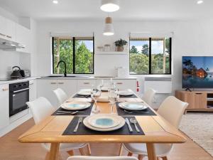 a kitchen and dining room with a wooden table and chairs at Kirwan 19 in Jindabyne