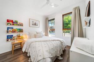 a bedroom with a bed and a desk and a window at Chalfont Way @ Glengowrie - WiFi BBQ Family in Somerton Park