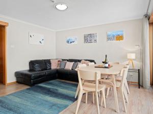 a living room with a table and a couch at Mowamba D1 in Thredbo