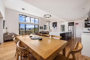 Una cocina y una sala de estar con una mesa y sillas de madera. en Moongate, en Jindabyne