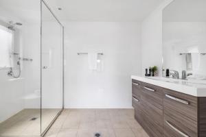Un baño con ducha de cristal y lavabo. en Moongate, en Jindabyne 24 fotos más