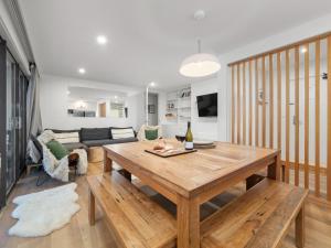 a living room with a wooden table and a couch at Mowamba A1 in Thredbo