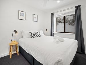 a bedroom with a large bed and a window at Mowamba A1 in Thredbo
