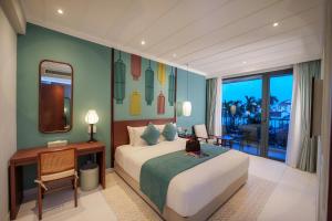 a bedroom with a bed and a table and a mirror at Cozy An Boutique Hotel Hoian in Hoi An +94 photos