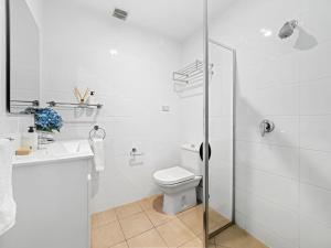 a white bathroom with a toilet and a sink at Snowbound 1 in Thredbo