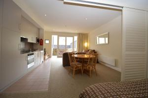 a kitchen and a dining room with a table in a room at Squatters Run 1 in Thredbo