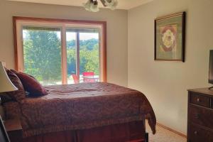 ein Schlafzimmer mit einem Bett und einem großen Fenster in der Unterkunft LI Airbnb - NWA mt bike, hike, and golf retreat in Bella Vista