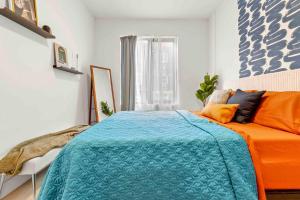 een slaapkamer met een oranje en blauw bed en een raam bij Contemporary Luxury BR, EWR AIRPT, Nyc, Free Pkng, Prudential CNTR, American Dream Mall in Elizabeth