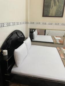 2 stapelbedden met witte kussens in een kamer bij QUỲNH HOA HOTEL in Ho Chi Minh-stad