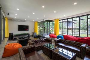a living room with leather couches and a pool table at Phrip Phri Luxury Pool Villas in Phetchaburi