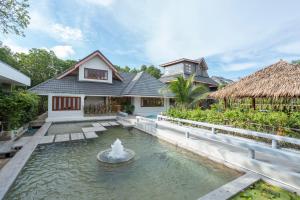 a house with a fountain in front of a house at Phrip Phri Luxury Pool Villas in Phetchaburi