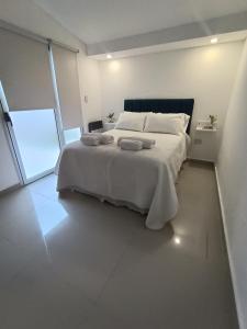 1 dormitorio con 1 cama grande y 2 toallas. en Departamento Elena 2 en Santa Rosa