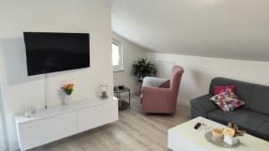 uma sala de estar com um sofá e uma televisão na parede em Apartman Polaris Posušje em Posušje