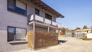 a house with a balcony on the side of it at Yurali in Jindabyne