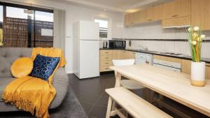 a kitchen and living room with a couch and a table at Yurali in Jindabyne +3 photos