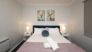 a bedroom with a large bed with two night stands at Yurali in Jindabyne