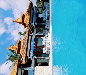 a building with chairs and a pool in the water at Soul Lodge Villa Lovina in Banjar