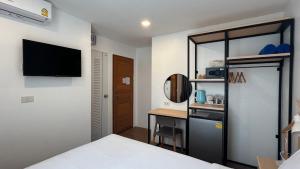 a bedroom with a bed and a desk and a television at B3 HOUSE in Kamala Beach