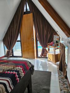 um quarto com uma cama e uma grande janela em Guillen Plantaciones Resort Farm em Cebu