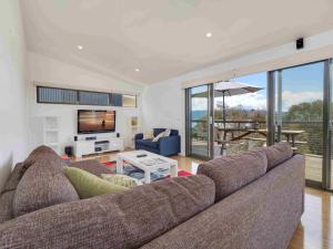 a living room with a couch and a television at Alpine Freedom in Jindabyne