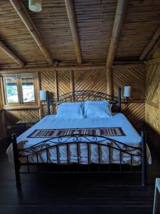 Ce lit se trouve dans un dortoir doté d'un plafond en bois. dans l'établissement GOLDEN TREE MINDO ECO-LODGE, à Mindo