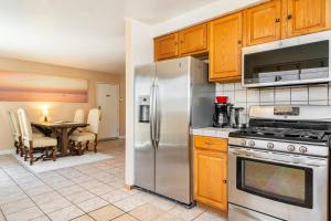 a kitchen with a stainless steel refrigerator and a table at MaGiQ Manor-2 Rooms-1 BRM w Yard-No Shared Space in Spring Valley