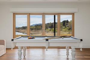 sala de estar con mesa de billar frente a una ventana en Kosci Lakeside B, en Jindabyne