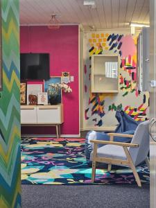 a colorful room with a chair and a tv at Hello! Accommodation in Tauranga
