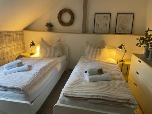 two beds in a small room with two lamps at Weberhof Apartment 6 in Münster