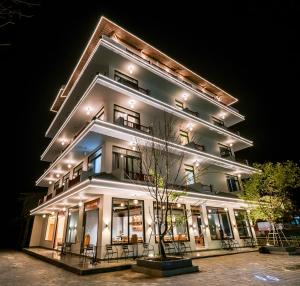 a large white building at night at Khách sạn Kumo Chan Mộc Châu in Mộc Châu