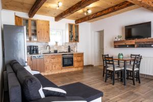 a living room with a couch and a table in a kitchen at Alpakavendégház in Balatoncsicsó