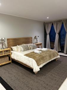 a bedroom with a large bed with two towels on it at The Pier 27 in Swakopmund